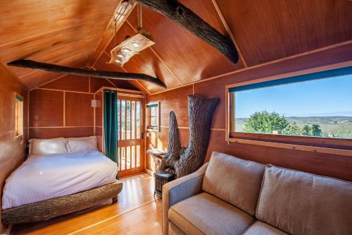 坎特伯雷Oakside Tree Tops的一间卧室配有一张床、一张沙发和一个窗口