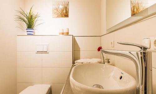 阿伦斯霍普Darßzeit的白色的浴室设有水槽和卫生间。