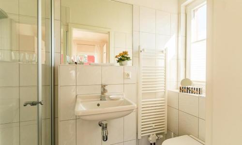 阿伦斯霍普Meertraum的白色的浴室设有水槽和淋浴。