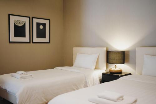 七岩华欣棕榈湾畔酒店的两张睡床彼此相邻,位于一个房间里