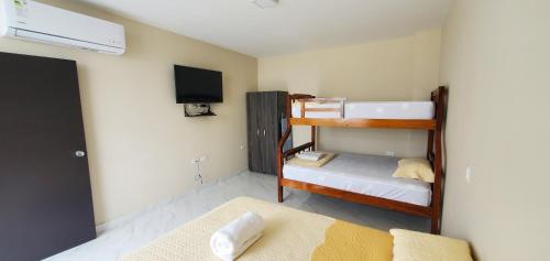 瓜亚基尔NCG SUITE Centro的客房设有两张双层床和电视。