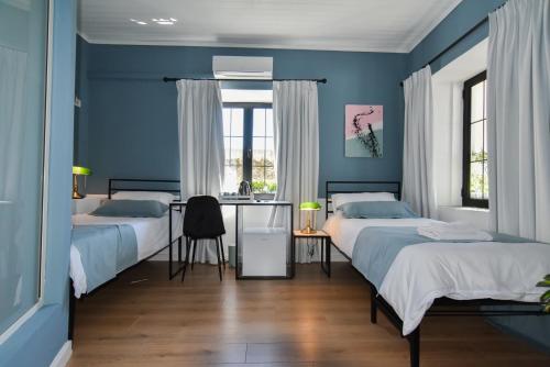斯库台Atelier Boutique Hotel的一间蓝色卧室,配有两张床和一张书桌