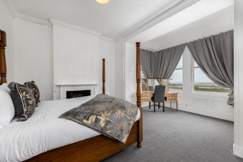 雷文格拉斯Muncaster Cottages的卧室配有一张床、一张书桌和窗户。