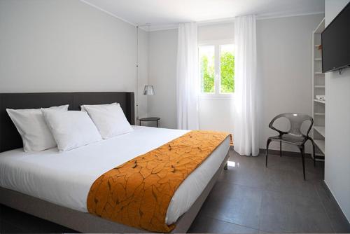 利勒鲁斯Residence Saletta Casale的卧室配有床、椅子和窗户。