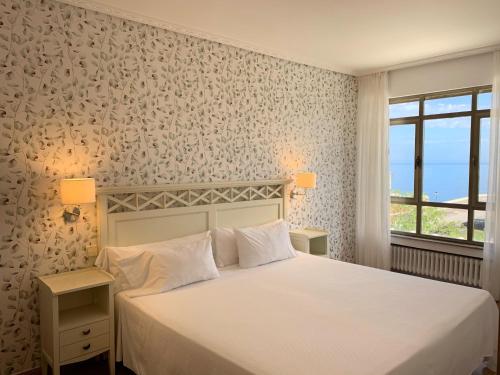 苏安塞斯Hotel Playa de Los Locos的卧室配有白色的床和窗户。