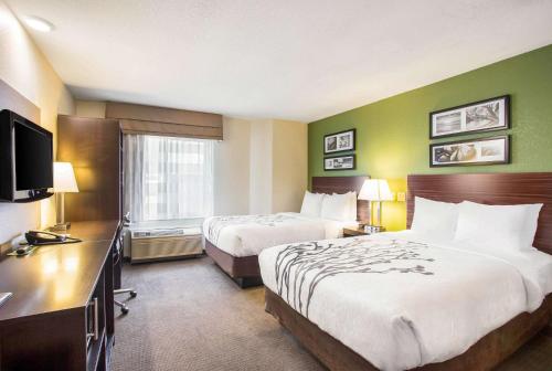 堪萨斯城堪萨斯城国际机场司丽普酒店的酒店客房设有两张床和电视。