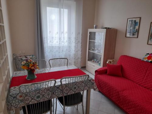 阿斯蒂Appartamento Centrale con garage的客厅配有红色桌子和沙发