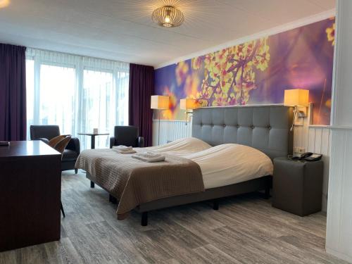 斯希蒙尼克奥赫山丘景观咖啡餐厅酒店的卧室配有一张床,墙上挂有绘画作品