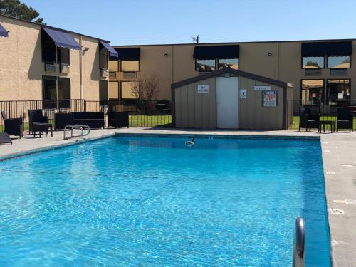 阿比林Abilene Whitten Inn的大楼前的大型蓝色游泳池