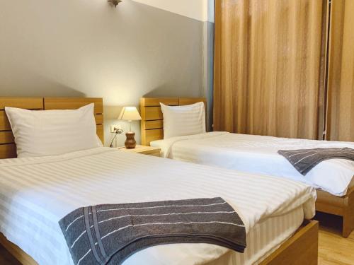 曼谷枕头和面包旅舍的配有2盏灯的酒店客房的2张床