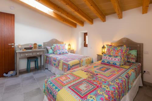 阿尔塔Casa Abeurador, con mucho encanto en el centro de Artà的一间卧室设有两张床和一张带炉灶的桌子。