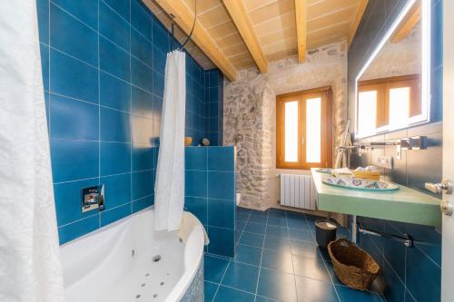 阿尔塔Casa Abeurador, con mucho encanto en el centro de Artà的蓝色的浴室设有浴缸和水槽