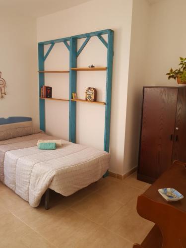 罗萨里奥港Laurainu的卧室配有一张床,墙上设有架子