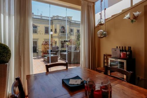 佛罗伦萨瓦伦提诺豪华II酒店的一间带桌子和大窗户的用餐室