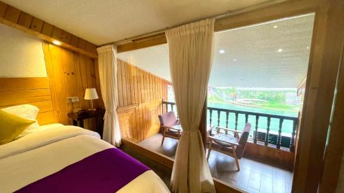 凤凰边城杏子客栈 的一间卧室设有1张床和1扇窗户的阳台