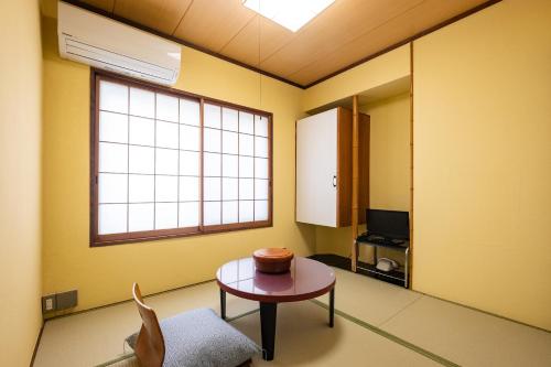 热海素泊まり宿　瑞宝荘的一间设有桌子和窗户的客房