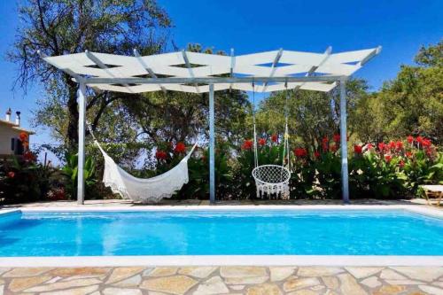 卡拉米锡Sea Breeze Apartments - n.1 with private pool的白色遮阳伞和泳池旁的吊床