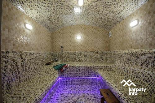 科索夫Хамам Вілла Даросо з басейном的浴室设有紫色灯和浴缸
