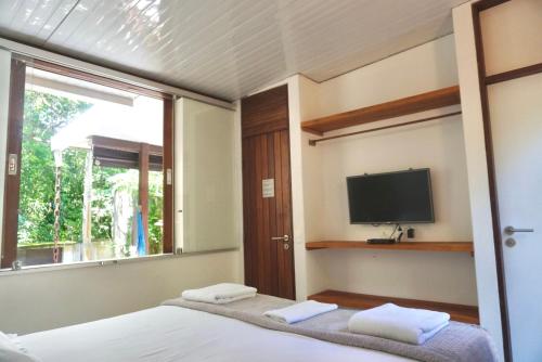 马利西亚斯Chalés Maritacas的一间卧室设有一张床、电视和窗户