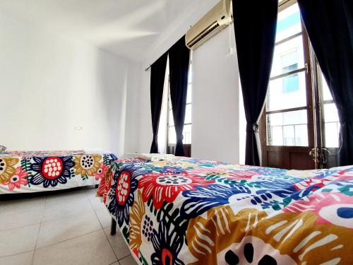 科尔多瓦Arc House Ribera Only Adults的一间卧室配有两张带彩色床单的床
