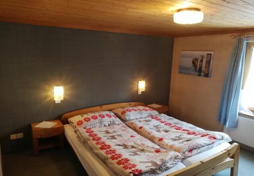 迈恩费尔德Hotel Alpenrose的一间卧室配有一张大床,提供红白毯子