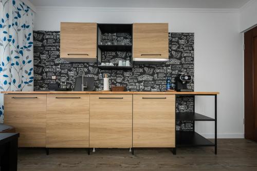 耶莱尼亚古拉ApartsW241的厨房配有木制橱柜和黑白壁纸。