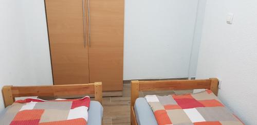 特拉夫尼克Apartman za dvoje的一间卧室配有两张床和一个衣柜