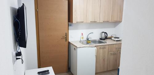 特拉夫尼克Apartman za dvoje的一间带水槽和冰箱的小厨房