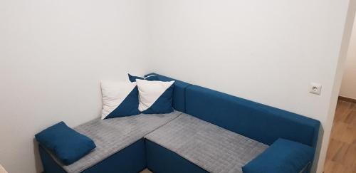 特拉夫尼克Apartman za dvoje的客房内的蓝色长椅和两个枕头