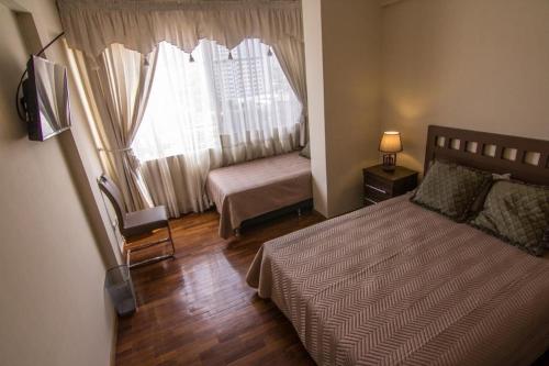 科恰班巴Un lugar familiar的一间小卧室,配有床和窗户