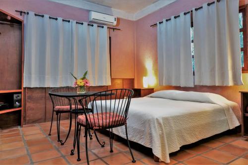 伊萨马尔Hacienda Hotel Santo Domingo的卧室配有一张床和一张桌子及椅子