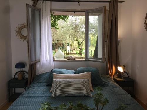 迈兹Domaine Sesquier Mas d'exception Jasmin的一间卧室设有一张带窗户和窗户的床。