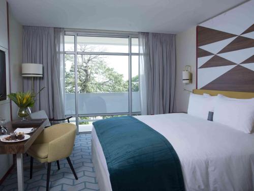 阿比让阿比让科特迪瓦索菲特酒店的配有一张床、一张书桌和一扇窗户的酒店客房