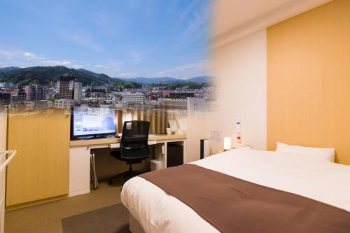 高山奥尔皮娜海达高山市Spa酒店的一间卧室配有一张床和一张带电脑的书桌