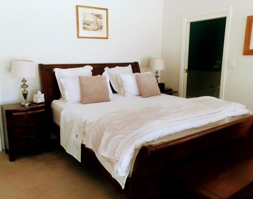 AngastonAngaston Lodge的卧室配有一张带白色床单和枕头的大床。