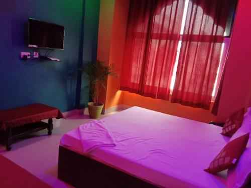 珀勒德布尔Vamoose Raj Palace的一间卧室配有一张带粉红色照明的大床