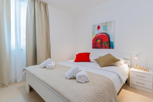 内里吉恩Apartments Lopari的白色卧室配有两张带毛巾的床
