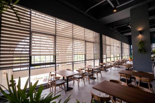 马西D ELEGANCE GRAND BANDAR SERI ALAM的餐厅设有桌椅和大窗户。