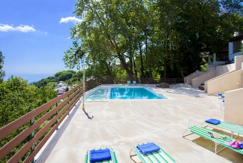 扎戈拉Luxury Villa at Pelion- Ruby的一个带2把躺椅和围栏的游泳池