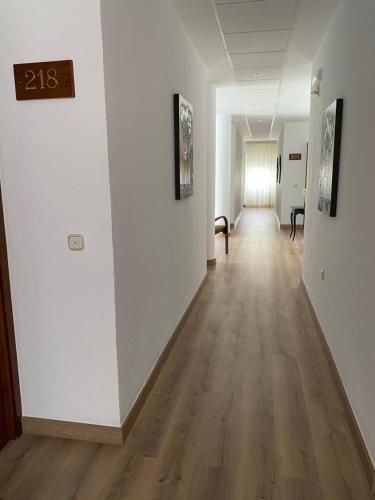 尼哈尔文塔德尔博布里酒店的空的走廊设有白色的墙壁和木地板