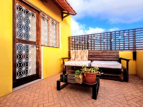 明德卢Casa Bom Dia的阳台,带长凳,门和植物