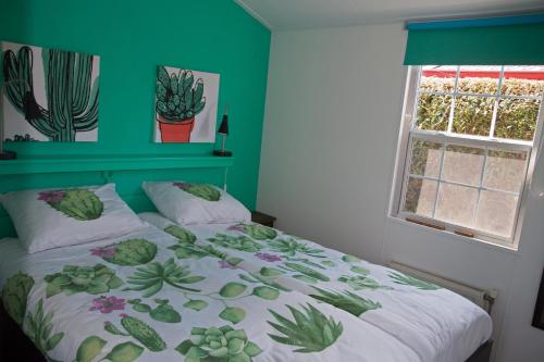 斯赫拉芬赞德dutchduochalet37的一间卧室配有一张带绿色墙壁的床