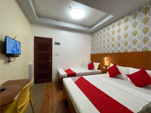 麦克坦OYO 685 K Fortune Apartelle的酒店客房设有两张床和电视。