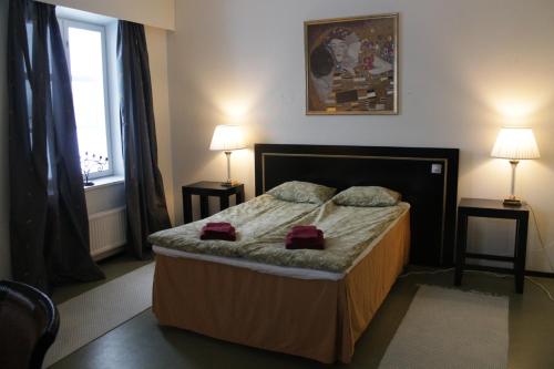 NivalaJokihovi的一间卧室配有一张带两盏灯的床和一扇窗户。
