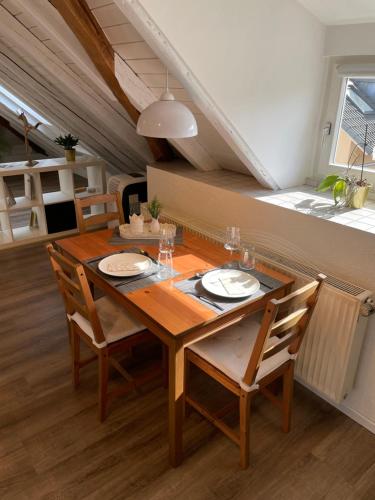 腓特烈港Ferienwohnung Schneider Friedrichshafen的一间带木桌和椅子的用餐室
