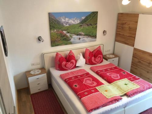 Sankt Johann im SaggautalGästehaus Schmid的一间卧室配有红色枕头的床