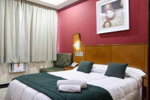卡希亚斯公爵城卡普里酒店的一间卧室设有一张大床和红色的墙壁