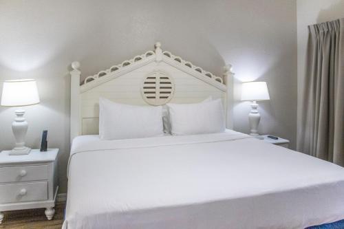 奥兰多钻石度假村布莱恩的西班牙湾公寓式酒店的卧室配有带两盏灯的白色床