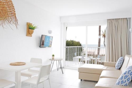 阿尔库迪亚港Bonavida Apartments的客厅配有白色的沙发和桌子
