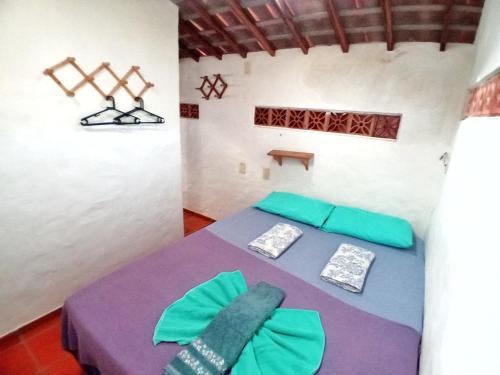 雅克南Casa da Lua的客房配有一张带绿色和紫色枕头的床。
